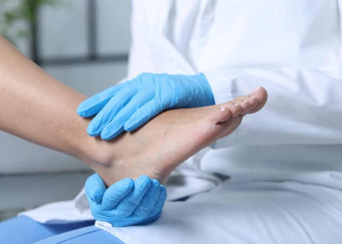 Doctor examining patient's foot in hospital, closeup