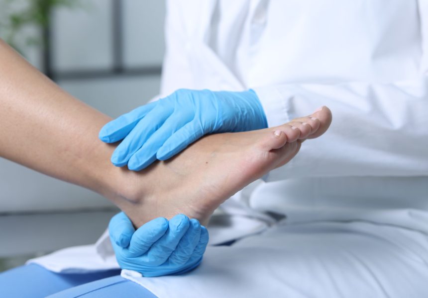 Doctor examining patient's foot in hospital, closeup